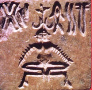 Mohenjo-Daro'da bulunan bir mühür. Muhtemelen Yoga pozisyonunda oturan bir kadını tasvir etmekte. (2.65 x 2.7 cm)